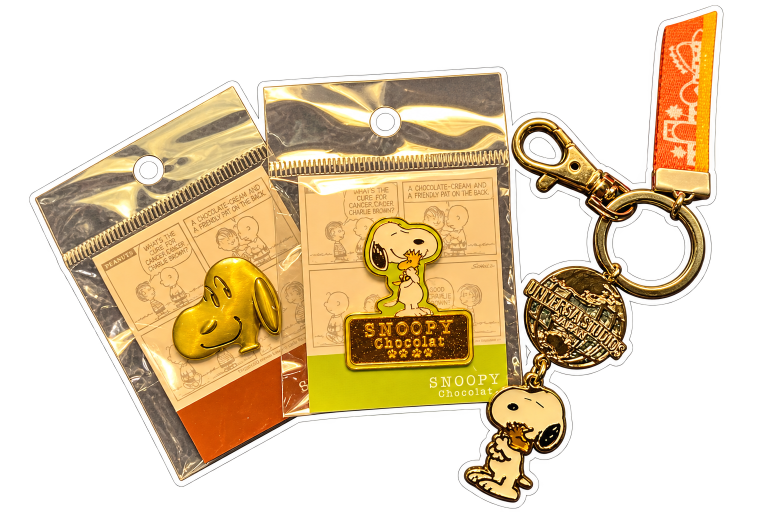 Two Snoopy pins and a Snoopy keychain